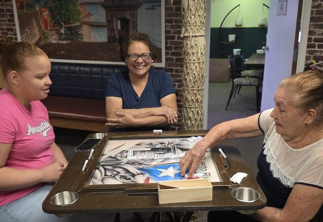 Members playing dominoes in the La Placita room